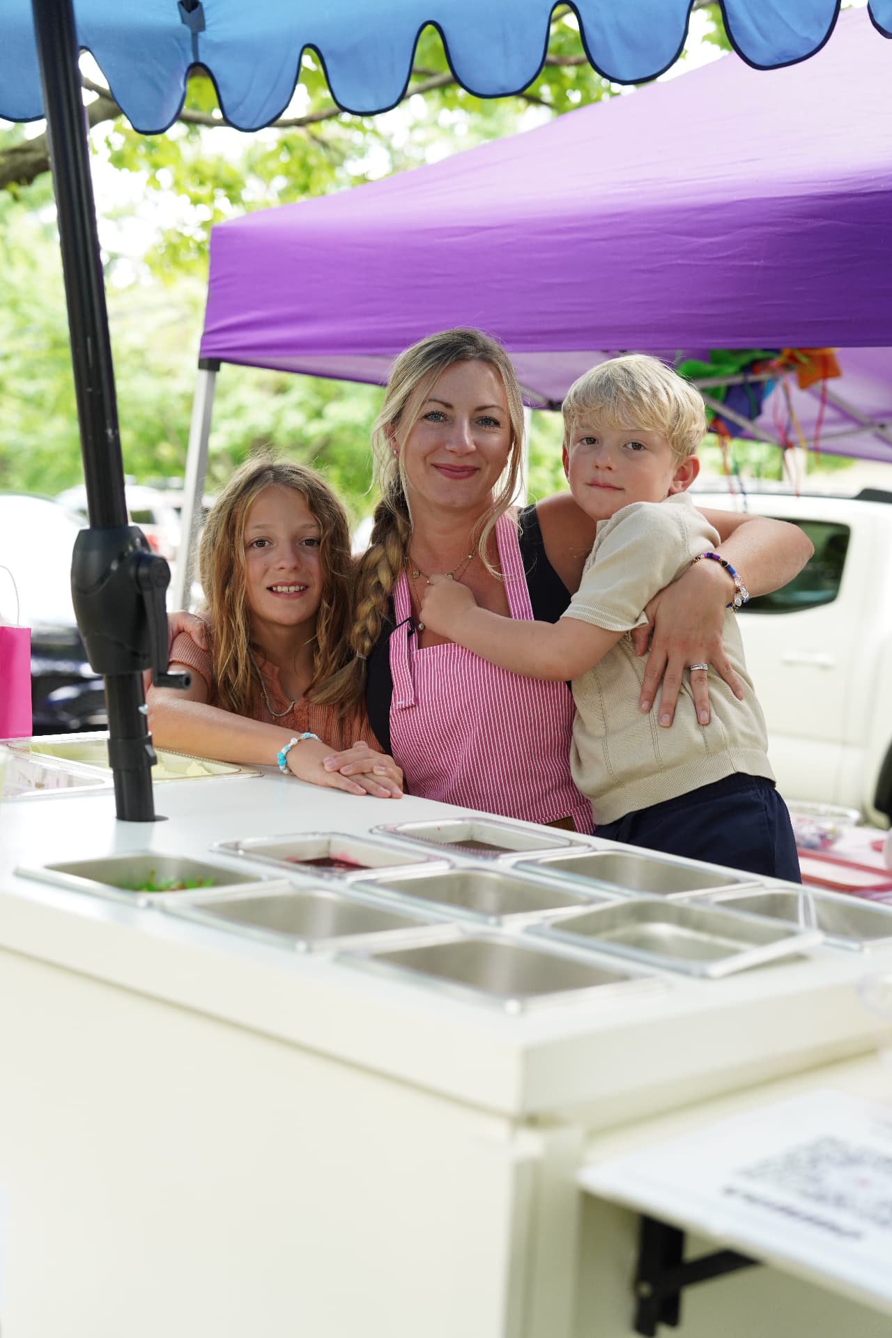 Janelle and her kids behind the Jellybean Event Cart at a party