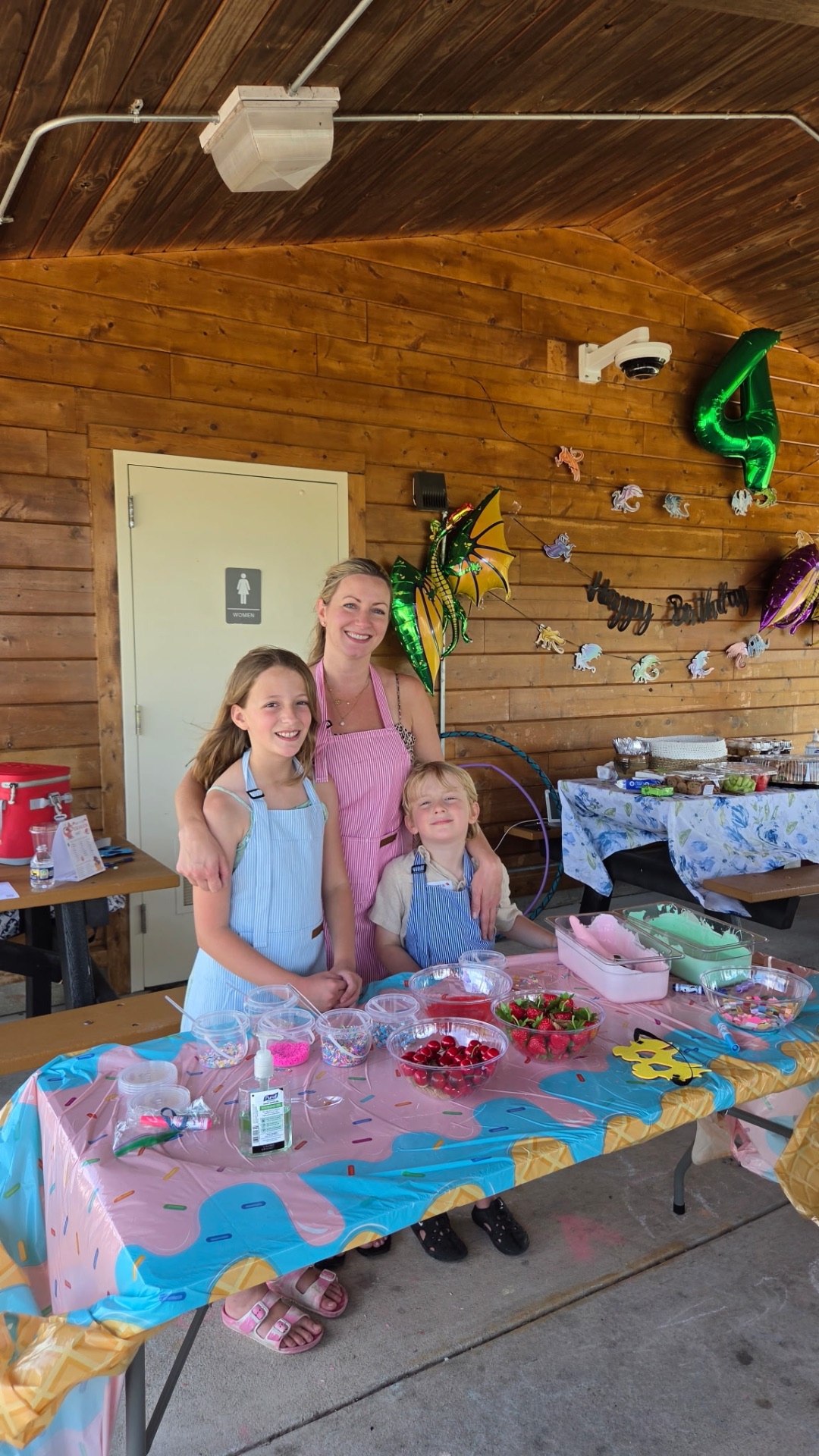 Janelle with her two kids behind a decorated party cart